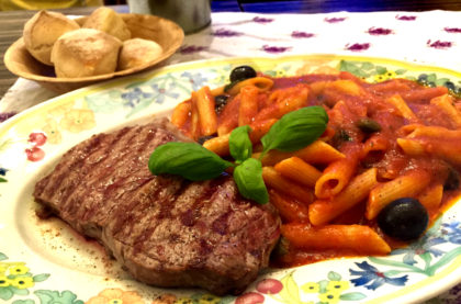 Bistecca vom Grill mit Pasta, Tomatensauce und Oliven